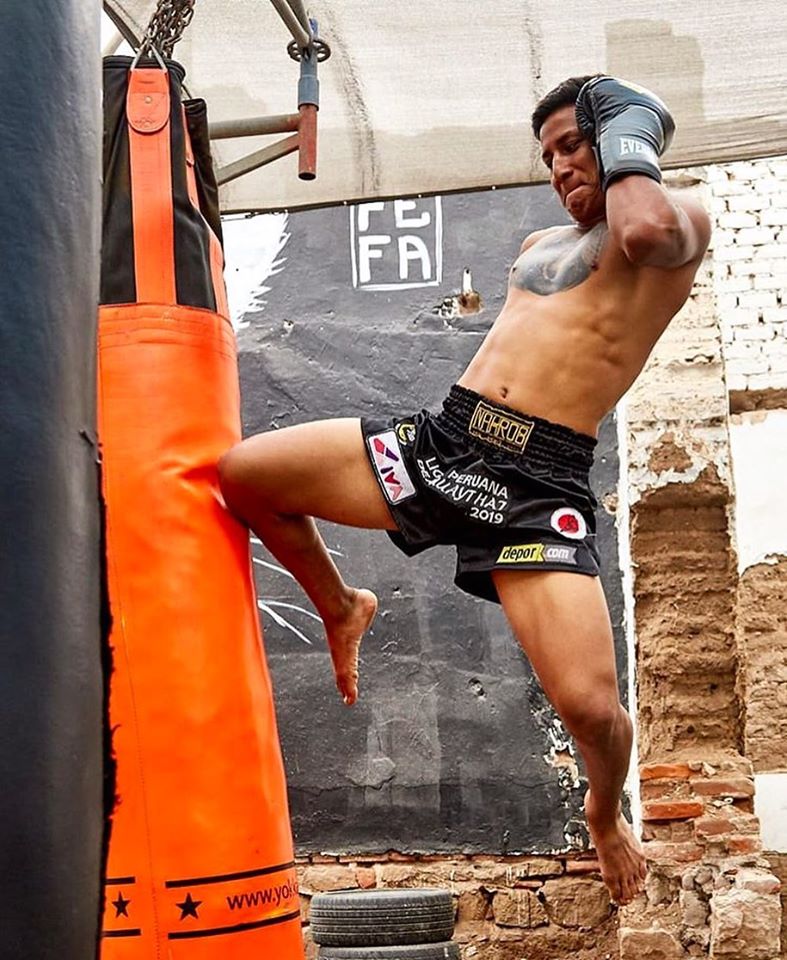 peleador liga peruana de muaythai lanzando una rodilla al saco